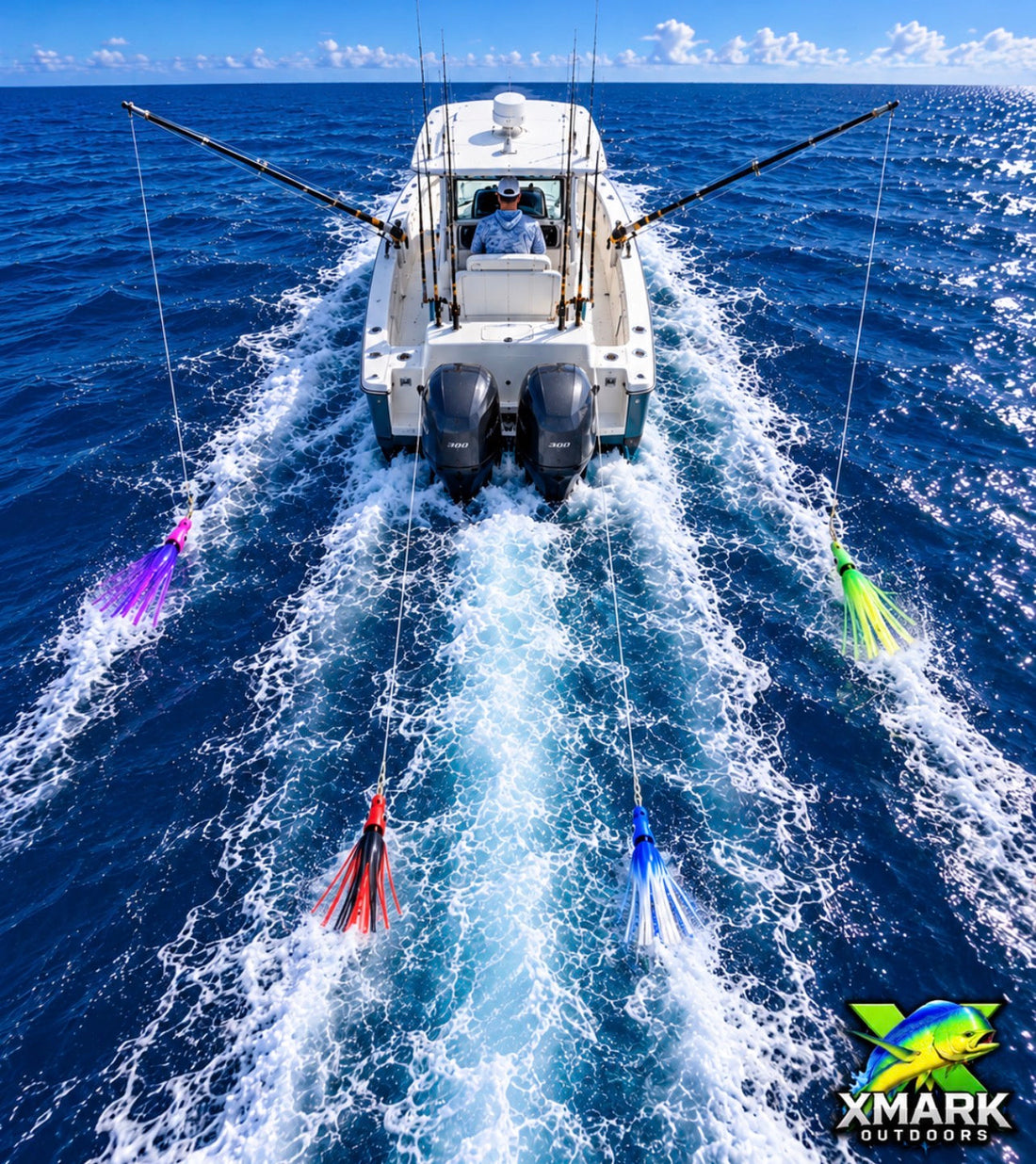 Overhead view of an offshore boat underway at trolling speed with four squid-style lures visible in an organized spread behind the boat. Two